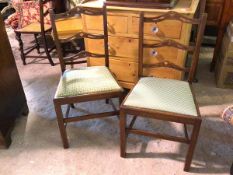 A pair of early 20thc side chairs, with pierced yoke ladder backs and upholstered drop in seats,