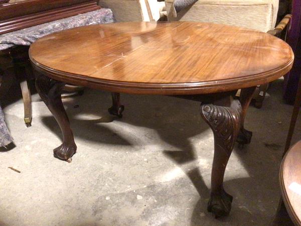 A 19thc mahogany dining table, the oval top with moulded edge on cabriole supports with acanthus