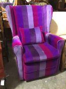 A modern wing back armchair in striped purple tone upholstery, with scatter cushion, on castors (