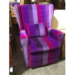 A modern wing back armchair in striped purple tone upholstery, with scatter cushion, on castors (