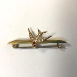 A 9ct gold bar brooch mounted with a swallow set with ruby and two seed pearls (4.5cm) (2.32g)