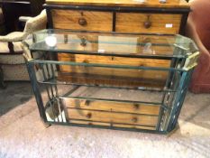 A contemporary console table with verdigris and metal frame, with bevelled glass top above a glass