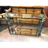 A contemporary console table with verdigris and metal frame, with bevelled glass top above a glass