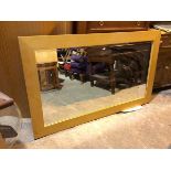 A modern wall mirror, the bevelled glass within an oak frame (90cm x 105cm)