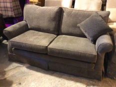 A modern two seater sofa in a herringbone pattern upholstery, with rolled arms on castors (85cm x