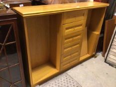 A modern oak bookcase with central bank of six drawers flanked by adjustable shelves on plinth