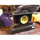 An Edwardian slate mantle clock of typical architectural form, with pediment depiciting cherubs (