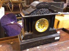 An Edwardian slate mantle clock of typical architectural form, with pediment depiciting cherubs (