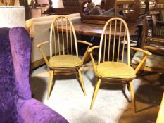 A pair of Ercol beech and elm armchairs, with hoop and spindle backs, upholstered seat cushions