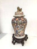 A modern Chinese lidded baluster vase with gilt lion finial, body with foliate decoration and four