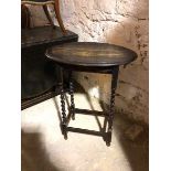 A 1930s/40s ebonised occasional table, the oval top with moulded edge on barley twist supports