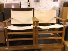 A pair of safari style chairs, the wooden frame with sling back and seat, on straight supports