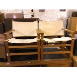 A pair of safari style chairs, the wooden frame with sling back and seat, on straight supports