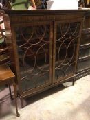 A George III mahogany bookcase, the moulded top above a dentil cornice, fitted two glazed doors with