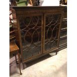 A George III mahogany bookcase, the moulded top above a dentil cornice, fitted two glazed doors with