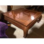 A large Chinese cherrywood coffee table with square chanelled top above a plain frieze, on moulded