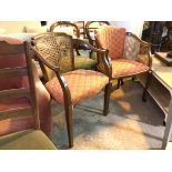 A similar pair of reproduction mahogany armchairs, both with cane and laurel wreath style