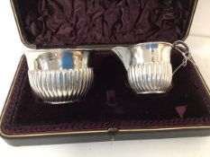 A late 19thc Birmingham silver milk jug and sugar bowl, both with gadrooned base, in original