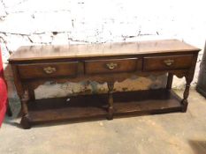 A George II style oak sideboard, the moulded top above three frieze drawers, above a lower tier