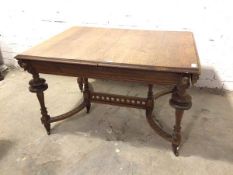 A 1920s/30s oak extending table lacking leaf, the top with moulded edges, with carved mask