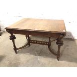 A 1920s/30s oak extending table lacking leaf, the top with moulded edges, with carved mask