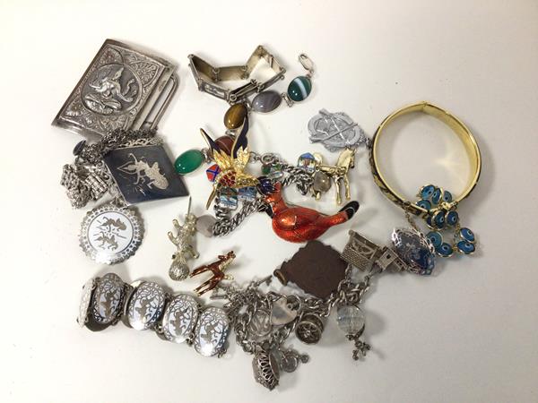 A collection of silver and costume jewellery including charm bracelets, belt buckle, bracelets,