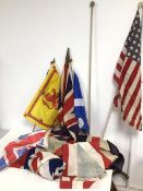 A collection of vintage flags, mostly Union Jacks but including an American Flag, with three