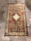 A North West Persian rug, with stylised flower within a geometric border, abrash and faded