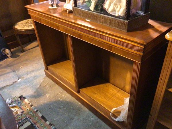 A modern open bookshelf with reeded cornice above a central vertical reeded divider with