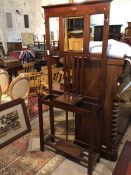 An early 20thc oak hallstand, with an arrangement of hooks around a bevelled rectangular mirror,