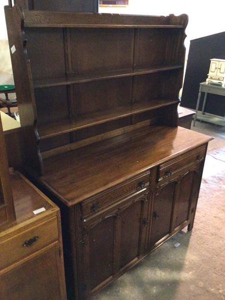 A 1930s/40s mahogany and oak dresser, with three shelf plate rail above a base fitted two frieze