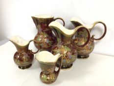 A collection of five 1930s/40s Crown Devon water jugs, two matching pair, the other three of various