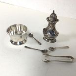 An Edwardian London silver pepperette, three salt spoons and a pair of sugar nips (combined: 100.