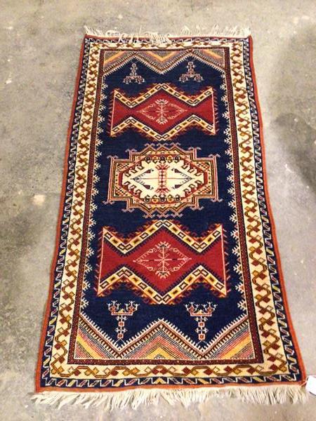 A North West Persian rug, with three geometric medallions, on blue field within geometric pattern