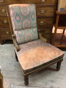 A late Victorian/Edwardian low chair with floral upholstered back and seat on turned front