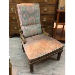 A late Victorian/Edwardian low chair with floral upholstered back and seat on turned front