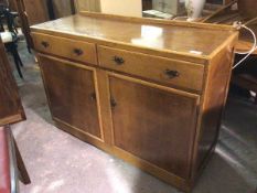 A 1930s/40s oak sideboard, with ledgeback above two frieze drawers and two cabinet doors, both