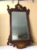 An Edwardian wall mirror, the bevelled mirror within a carved frame, with ho ho bird surmount and