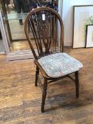 A 1930s/40s wagon wheel back Windsor armchair with upholstered seat pad on turned supports united by