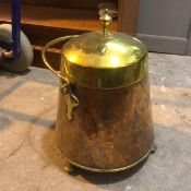 An early 20thc coal scuttle of conical form with swing handle, on bun feet, with a quantity of
