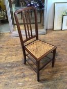 An Edwardian mahogany bedroom chair with cane seat on straight supports united by stretchers (94cm x