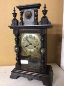 An early 20thc mantle clock with architectural pediment and lion mask, the dial with arabic numerals