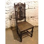 A 1920s oak side chair, with foliate carved crest rail and splat, above a plank seat, with