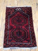 A North West Persian rug, with two stylised flowerhead medallions within geometric border (115cm x