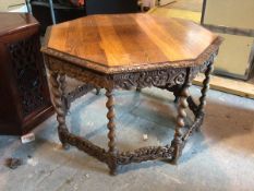 A 1920s/30s oak octagonal centre table with moulded edge above a carved apron, on barley twist