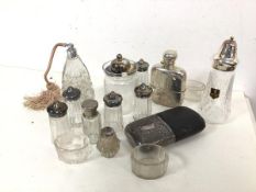 An assortment of glassware including an atomiser, a preserve jar, salts, shakers, two hip flasks,