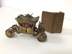 A miniature model of The Gold State Coach (4cm x 7cm x 3cm) (losses) and a miniature holy Bible (2)