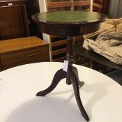 A Georgian style wine table with tooled leather circular top, fitted single frieze drawer, on turned