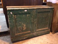 A distressed green painted dresser base with two panel doors, each with two shelves to interior,