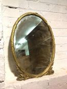 A gilt composition oval wall mirror with bevelled glass within classically inspired frame (59cm x